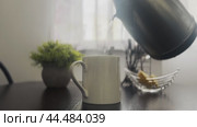 Early in the morning, tea is brewed on the kitchen table in a white mug. Close-up. Стоковое видео, видеограф Ярославский Максим / Фотобанк Лори
