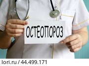 ОСТЕОПОРОЗ - слово на белом листе в руках врача. Стоковое фото, фотограф Жанна Гапанович / Фотобанк Лори