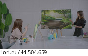 Two women painting a picture of a forest. Стоковое видео, видеограф Константин Шишкин / Фотобанк Лори