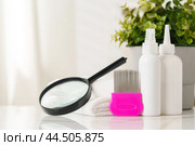 Lice treatment product next to a nit comb and magnifying glass. Стоковое фото, фотограф Сергей Толмачёв / Фотобанк Лори