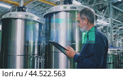 An engineer checks the data of boilers in a brewery. Стоковое AI-видео, аниматор Юрий Поздников / Фотобанк Лори