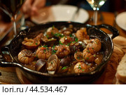 Sizzling seafood delight in skillet. Стоковое AI-изображение, AI-художник Иван Рябоконь / Фотобанк Лори