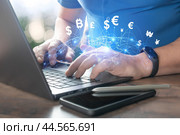 Currency exchange, money transfer, FinTech financial technology, Global business, online banking, interbank payment concept. Man using laptop computer with virtual international currencies and globe. Стоковое фото, фотограф Павел Муравьев / Фотобанк Лори