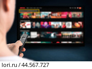 Person relaxing at home in evening and watching TV. Multimedia Television video streaming, Media TV on demand. Subscription Streaming video. Internet streaming service concept. Стоковое фото, фотограф Павел Муравьев / Фотобанк Лори