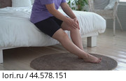 Knee pain, joint inflammation, arthritis and degenerative changes, woman suffering from leg ache and doing self-massage at home. Стоковое видео, видеограф Станислав Тарко / Фотобанк Лори