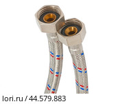 Сантехнический шланг в металлической оплетке для воды на белом фоне. Plumbing hose in a metal braid for water. Стоковое фото, фотограф Татьяна Д / Фотобанк Лори