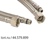 Сантехнический шланг в металлической оплетке для воды на белом фоне. Plumbing hose in a metal braid for water. Стоковое фото, фотограф Татьяна Д / Фотобанк Лори