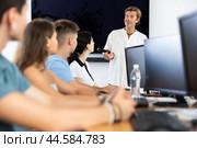 Adult man speaker stands in front of students and talks about use of artificial intelligence. Стоковое фото, фотограф Яков Филимонов / Фотобанк Лори