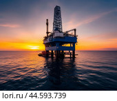 Offshore oil rig extracting oil against the backdrop of sunset. Стоковое AI-изображение, AI-художник Сергей Елизарьев / Фотобанк Лори