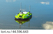 Moscow July 14 2024. A green boat is floating on the water. The boat is small and has a camera on it. an unmanned boat for hydrographic surveys from the bottom of a reservoir. Редакционное фото, фотограф Скрипачев Антон / Фотобанк Лори