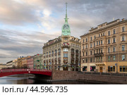 St. Petersburg, Russia, 04.30.2023: View of the historical building of the store "At the Red Bridge" of the Belgian-Dutch trading company "S.Esders and K.Scheifals" on the Moika River embankment. Редакционное фото, фотограф Ula Ulachka / Фотобанк Лори