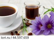 Healing drinks. Chicory drink. Cup of chicory drink and flowers on a white table. Стоковое AI-изображение, AI-художник Ирина Старикова / Фотобанк Лори