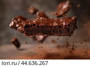 Captivating image showcasing a midair chocolate brownie with dynamic cocoa pieces scattered around. Стоковое AI-изображение, AI-художник Иван Рябоконь / Фотобанк Лори