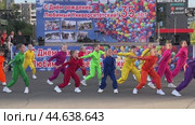 IRKUTSK, RUSSIA - September 06, 2024: An annual celebration in University district. Video of a group of schoolgirls in brightly colorful costumes dance funny sport dance on open stage on sunny September day. Редакционное видео, видеограф Виктория Катьянова / Фотобанк Лори