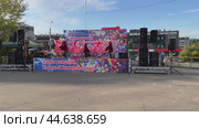 IRKUTSK, RUSSIA - September 06, 2024: Video of annual celebration in the University district. Group of schoolchildren in traditional fancy dress dance Russian folk dance on open stage on sunny September day. Редакционное видео, видеограф Виктория Катьянова / Фотобанк Лори