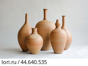Handcrafted clay pottery collection on neutral background. Стоковое AI-изображение, AI-художник Иван Рябоконь / Фотобанк Лори