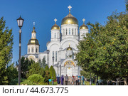 Паломники идут через яблоневый сад к Преображенскому Собору в Дивеевском монастыре (2024 год). Редакционное фото, фотограф Юрий Шурчков / Фотобанк Лори