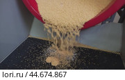 Red Hopper Pouring Yellow Granules Into Black Mat - coin blank polishing process. Стоковое видео, видеограф Гурьянов Андрей / Фотобанк Лори