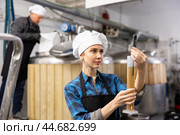 Female brewer using digital hydrometer for measuring beer density. Стоковое фото, фотограф Яков Филимонов / Фотобанк Лори