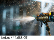 Professional spray gun applying paint creating a mist of tiny droplets. Стоковое AI-изображение, AI-художник Иван Рябоконь / Фотобанк Лори