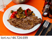 Delicious mediterranian style steak served with baked tomatoes and chili peppers. Стоковое фото, фотограф Яков Филимонов / Фотобанк Лори