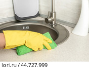 Deep Cleaning service. woman gloves hands cleaning kitchen sink. Surface sanitizing. Home cleaning spraying antibacterial spray bottle disinfecting. wearing nitrile gloves. Стоковое фото, фотограф Павел Муравьев / Фотобанк Лори
