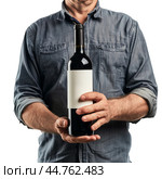 Winemaker holding a bottle of red wine with blank label. Стоковое AI-изображение, AI-художник Иван Рябоконь / Фотобанк Лори