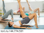 Girls at group Hatha yoga class does preliminary preparatory stretching. Стоковое фото, фотограф Яков Филимонов / Фотобанк Лори