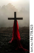 Wooden cross with red fabric in foggy background, concept of spirituality. Стоковое AI-изображение, AI-художник Анастасия Золотницкая / Фотобанк Лори