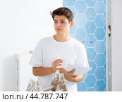 Young man owner is shocked by the estimate for the renovation of cottage. Стоковое фото, фотограф Яков Филимонов / Фотобанк Лори