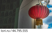 A bright red traditional Chinese lantern is suspended in the window opening of the temple. Golden stripes and fringes. Close-up. Malaysia. Penang. Kek Lok Si Temple (2023 год). Стоковое фото, фотограф Вера Ивановна Кубарева / Фотобанк Лори