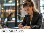 Young woman entrepreneur talking over telephone while working laptop at her desk. Busy Long hair businesswoman with office work holding cellphone device using mobile phone. Female worker calling phone. Стоковое AI-изображение, AI-художник Марина Демидюк / Фотобанк Лори