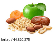 Green apple, peanuts, dates, dry apricots and oat flakes isolated on white background. Стоковое фото, фотограф Катерина Ковалева / Фотобанк Лори
