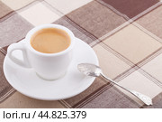 Кофейный натюрморт: белая чашка с кофе, мельхиоровая ложка на клетчатой скатерти. Стоковое фото, фотограф Александр Рыбалка / Фотобанк Лори