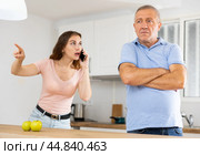 Adult daughter, talking on a mobile phone, is trying to prove her case to a frustrated father. Стоковое фото, фотограф Яков Филимонов / Фотобанк Лори