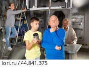 Grandson together with his grandfather solve the riddles of quest room. Стоковое фото, фотограф Яков Филимонов / Фотобанк Лори