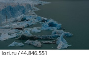 A fragment of a melting glacier. A wall of blue ice rises above a glacial lake. Melted ice floes float in the water. Perito Moreno. El Calafate. Lago Argentino. Los Glaciares National Park. Стоковое фото, фотограф Вера Ивановна Кубарева / Фотобанк Лори