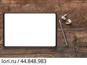 Digital tablet with empty white screen, stylus pen, wireless earphones on wooden rustic table. mockup. top view. Стоковое фото, фотограф Павел Муравьев / Фотобанк Лори