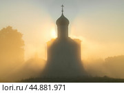 Силуэт средневековой церкви Покрова на Нерли на фоне восходящего солнца в утреннем тумане. Боголюбово. Стоковое фото, фотограф Виктор Карасев / Фотобанк Лори