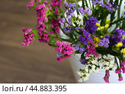 Bouquet of multicolored flowers in a vase (Limonium sinuatum, Statice sinuata) on a green background. Стоковое фото, фотограф Ирина Вершинская / Фотобанк Лори