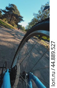 The rear wheel of a bicycle while driving in the early morning in a sunny park along a pond. The concept of a morning trip. Стоковое видео, видеограф Ярославский Максим / Фотобанк Лори