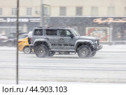 Tank 300 car is driving on city street during heavy snowfall. Side view of gray chinese SUV in motion. Редакционное фото, фотограф Константин Григорьев / Фотобанк Лори