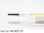 Ртутный градусник крупным планом на светлом фоне. Медицина и здравоохранение. Сезонная заболеваемость. Стоковое фото, фотограф Андрей Пустякин / Фотобанк Лори