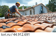 Construction worker repairing roof tiles on housetop. Стоковое AI-изображение, AI-художник Юрий Поздников / Фотобанк Лори