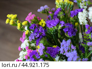 Bouquet of multicolored flowers in a vase (Limonium sinuatum, Statice sinuata) on a green background. Стоковое фото, фотограф Ирина Вершинская / Фотобанк Лори