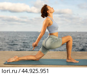 Yoga practice on embankment, female athlete fulfil carry out Anjaneyasana. Стоковое фото, фотограф Яков Филимонов / Фотобанк Лори