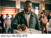 President elections. A black man votes for the new president of the United States of America and puts a form in the ballot box against the background of the American flag. Стоковое AI-изображение, AI-художник Photojuli / Фотобанк Лори