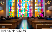 Stained glass windows illuminate a church during a weekend service filled with worshippers. Стоковое AI-изображение, AI-художник Ксения Лаптева / Фотобанк Лори
