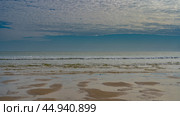 Seascape at low tide. Rivulets in the sand form a pattern. The waves of the ocean are rolling towards the shore, foaming. Clouds in the blue sky. Madagascar. Morondava. The Mozambique Channel. Стоковое фото, фотограф Вера Ивановна Кубарева / Фотобанк Лори