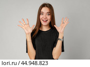 Young Woman Showing Surprise Expression on Gray Background. Стоковое фото, фотограф Сергей Толмачёв / Фотобанк Лори